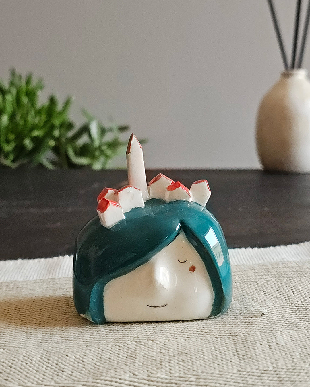 Testina in ceramica bianca con campanile e tetti di un paese in miniatura