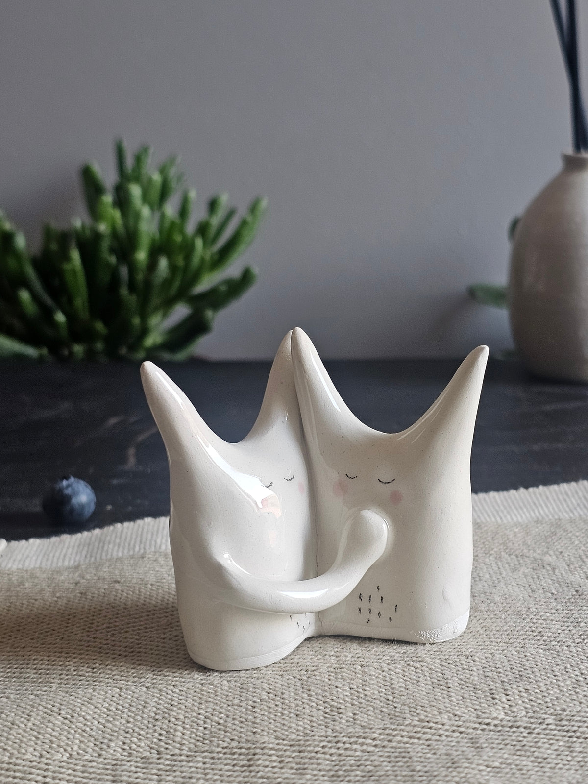Piccola scultura in ceramica bianca con espressione calma e rassicurante