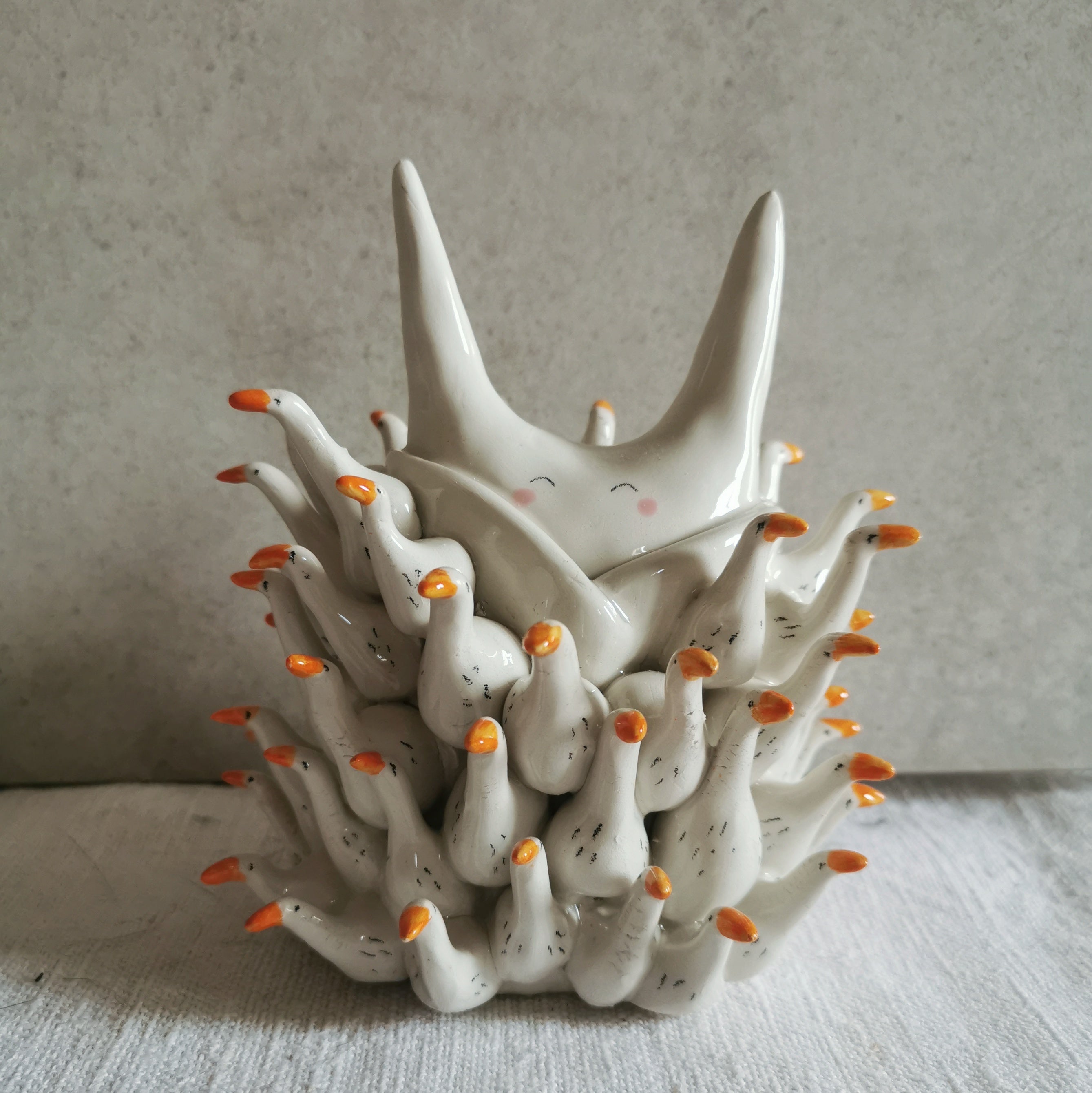 Scultura in ceramica bianca a tema piumino d'oche, decorata a mano