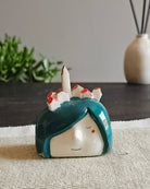 Testina in ceramica bianca con campanile e tetti di un paese in miniatura