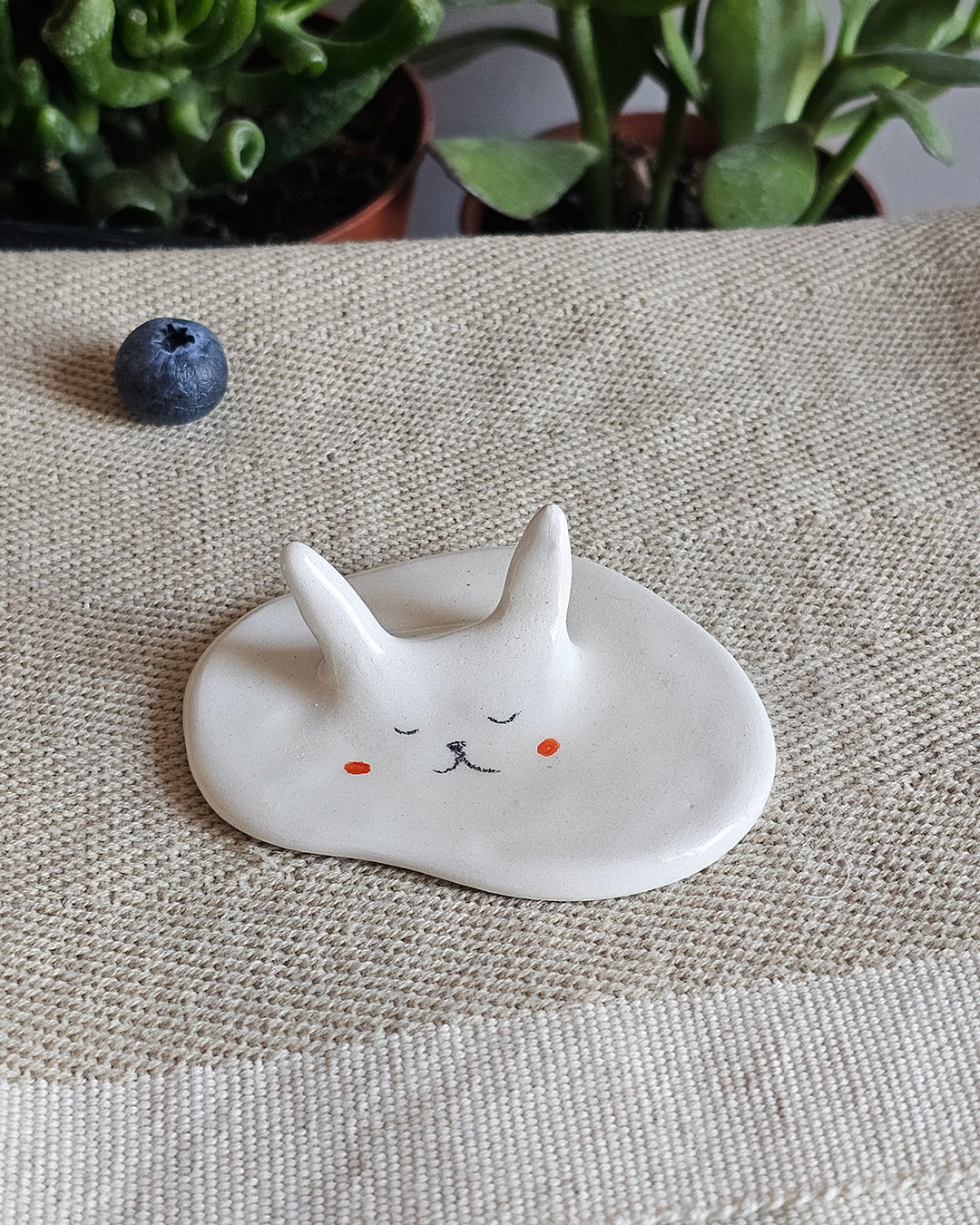 Coniglio in ceramica bianca sciolto e senza forma, con aria sognante