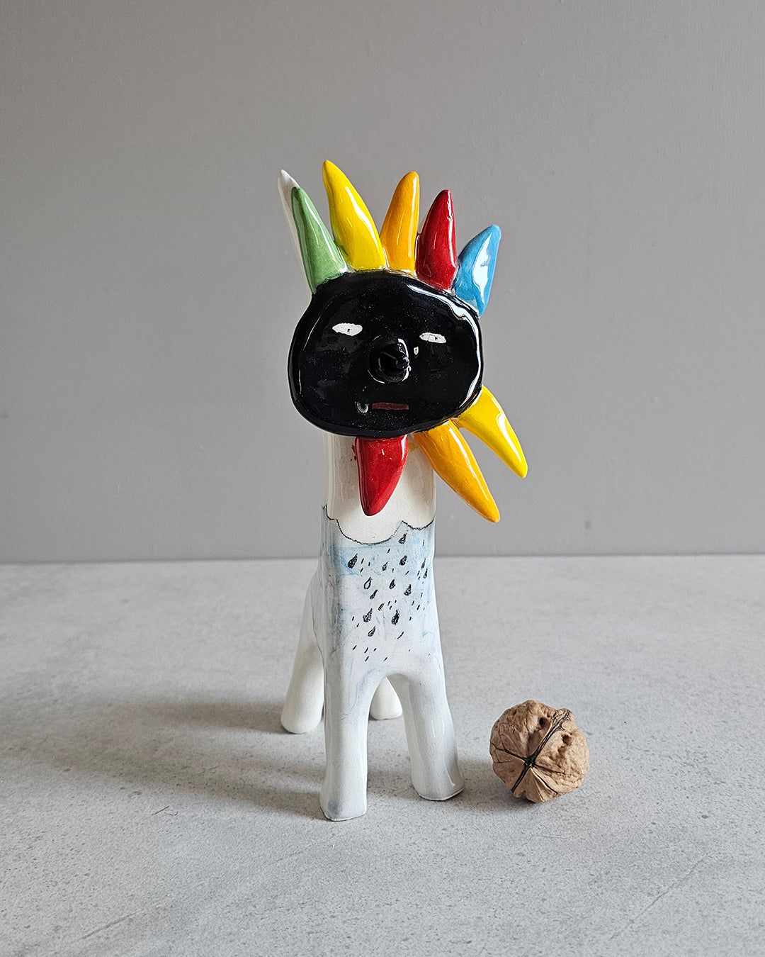 Scultura in ceramica di un sole nero, decorata e smaltata a mano