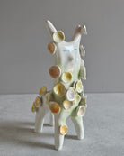 Scultura in ceramica di una figura che fiorisce, decorata a mano