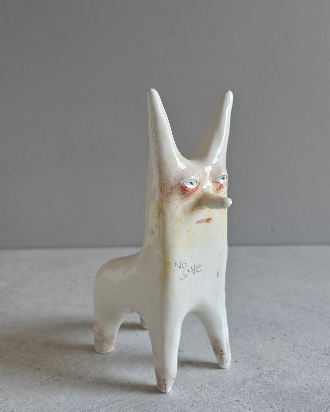 Scultura in ceramica a tema amore mancato, decorata e smaltata a mano