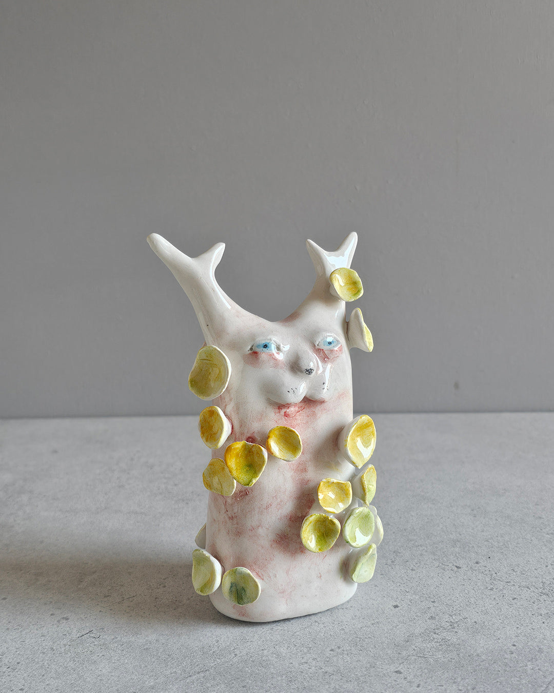 Scultura in ceramica di una figura che rifiorisce, decorata a mano