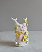 Scultura in ceramica di una figura che rifiorisce, decorata a mano