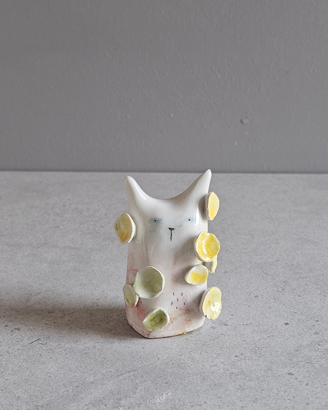 Scultura in ceramica di una figura in fiore, decorata e smaltata a mano