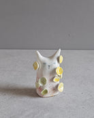 Scultura in ceramica di una figura in fiore, decorata e smaltata a mano