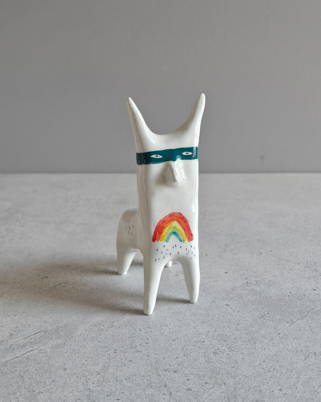 Scultura in ceramica di una figura felice che non vuole darlo a vedere