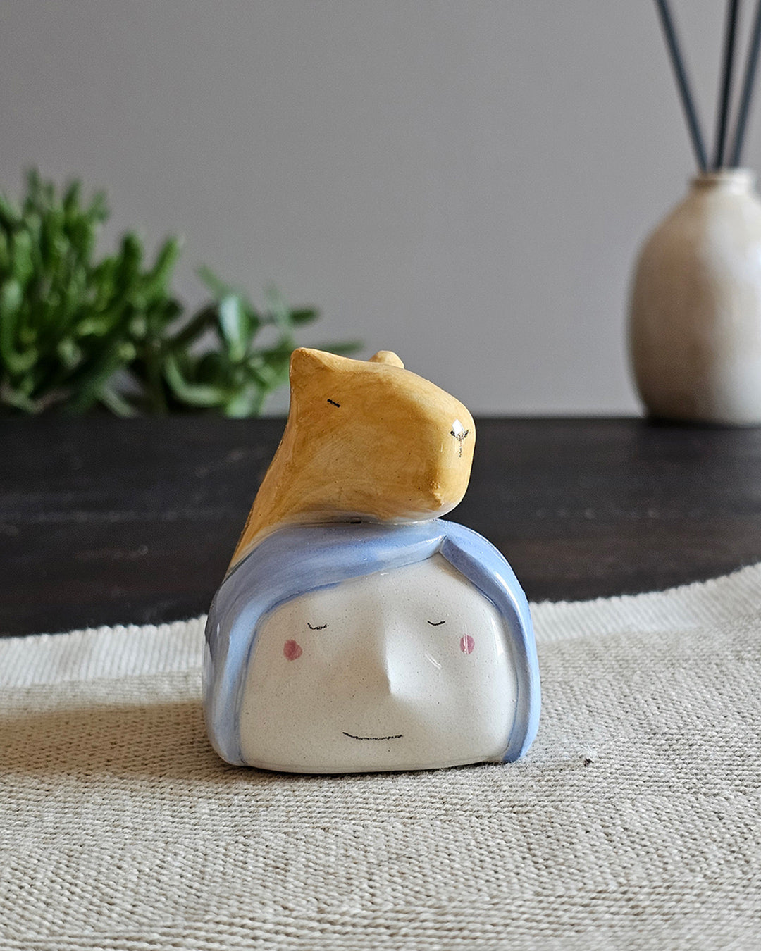 Testina in ceramica bianca con un capibara modellato a mano appoggiato in testa