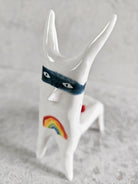 Scultura in ceramica bianca di una figura felice che si vergogna di mostrarlo