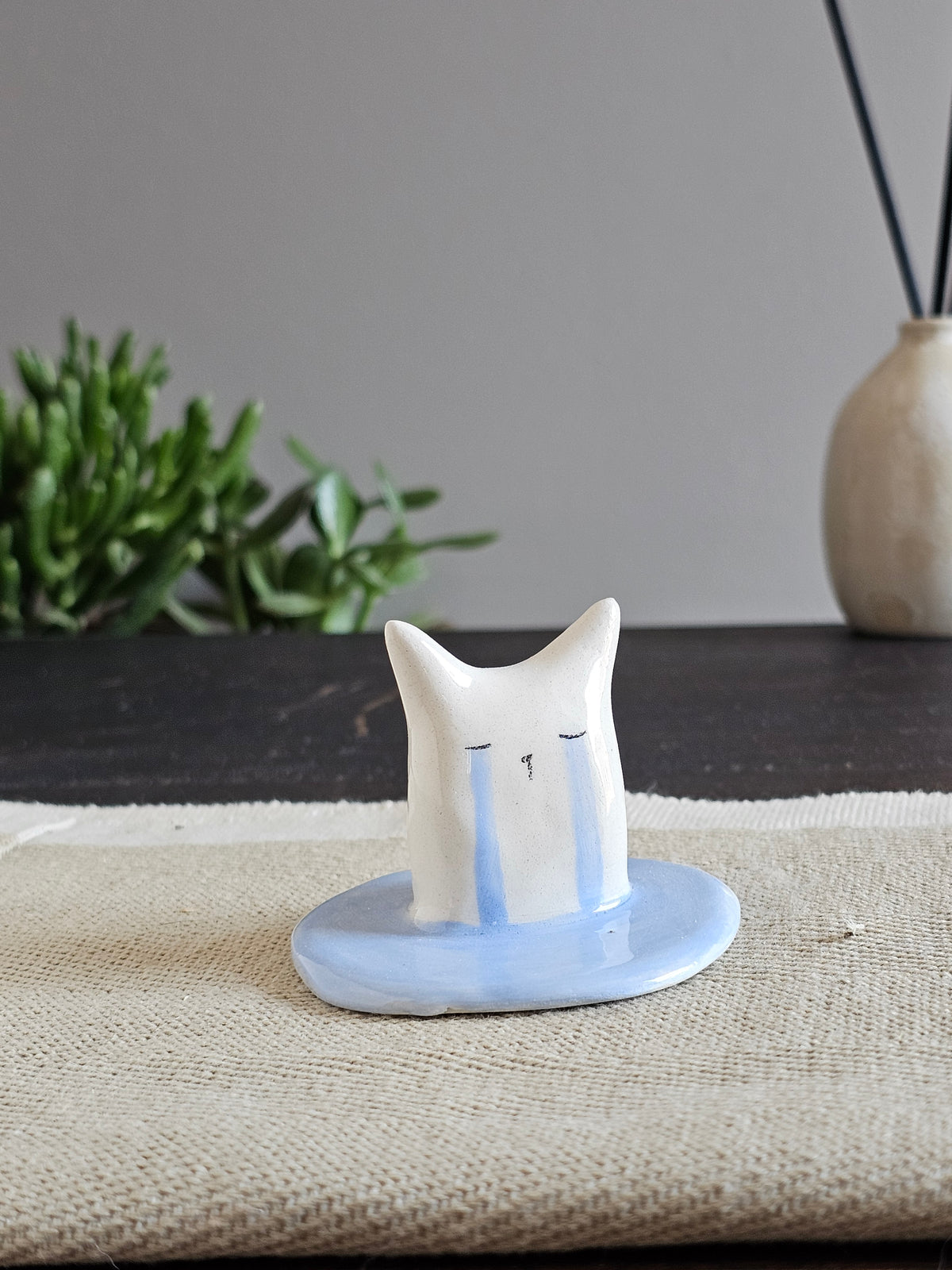 Scultura in ceramica bianca con una grande lacrima azzurra dipinta a mano