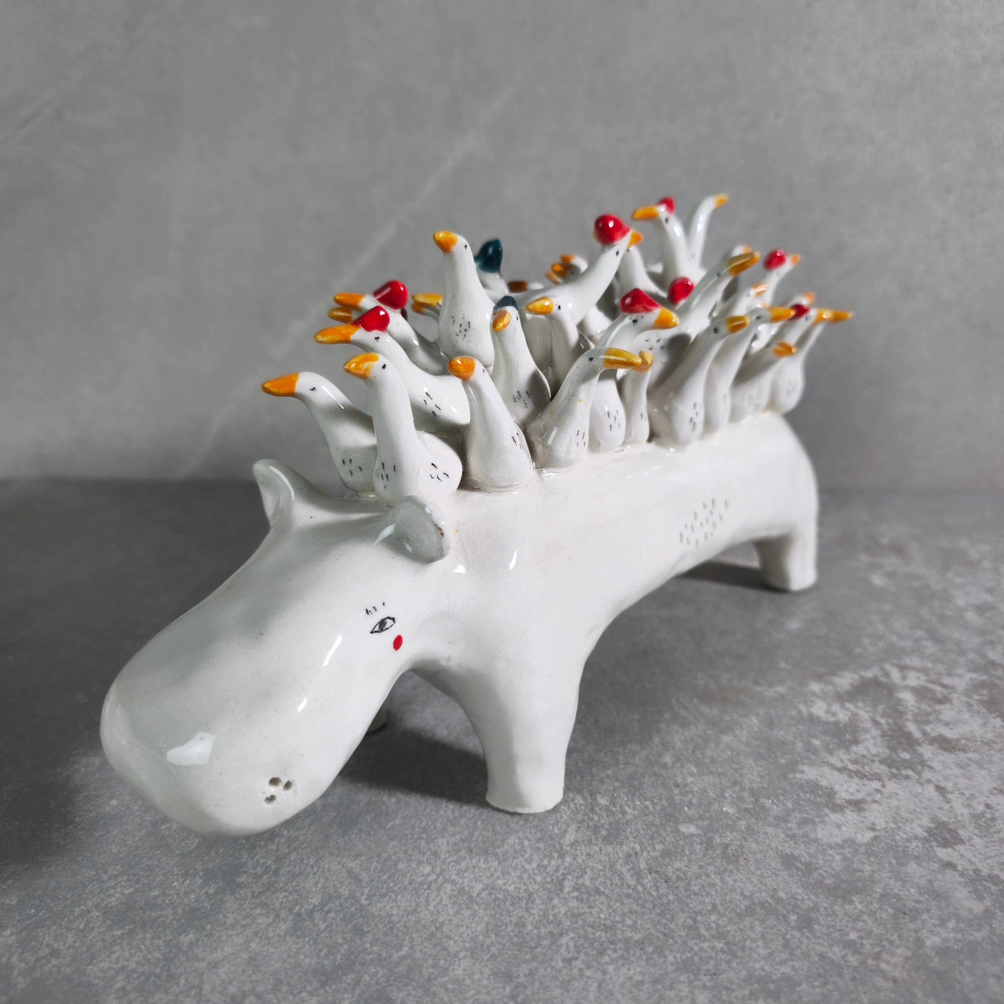 Grande ippopotamo in ceramica bianca che trasporta passeggeri sul dorso