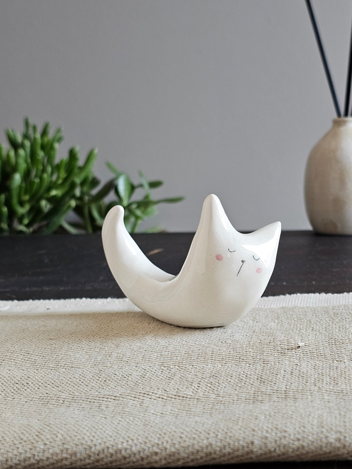 Animale in ceramica bianca disteso in avanti con la coda alzata
