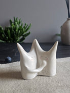 Piccola scultura in ceramica bianca con espressione calma e rassicurante
