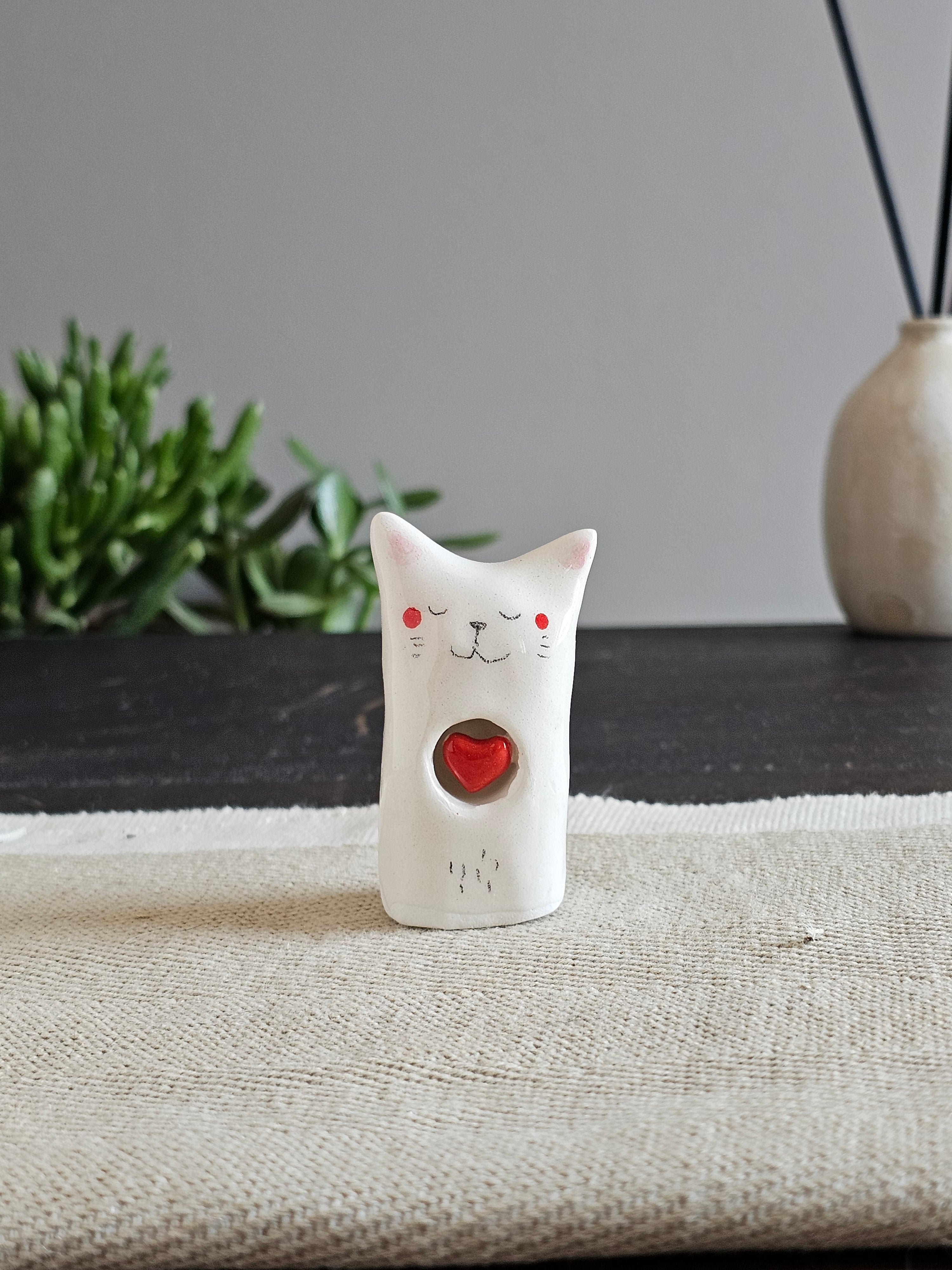 Scultura in ceramica bianca con un cuoricino disegnato a mano