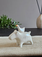 Capibara in ceramica bianca con cinque oche appoggiate sopra