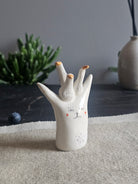 Scultura in ceramica bianca con un gruppo di oche modellate sulla testa