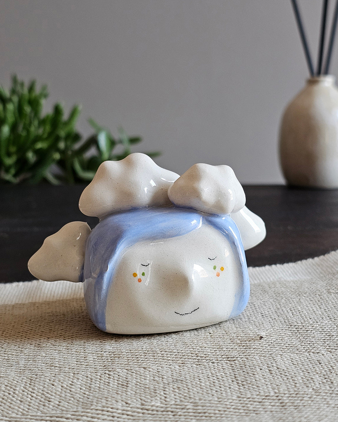 Testina in ceramica bianca con tre nuvole su capelli azzurri, fatta a mano