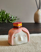 Testina in ceramica bianca con una fetta di zuppa inglese appoggiata in testa