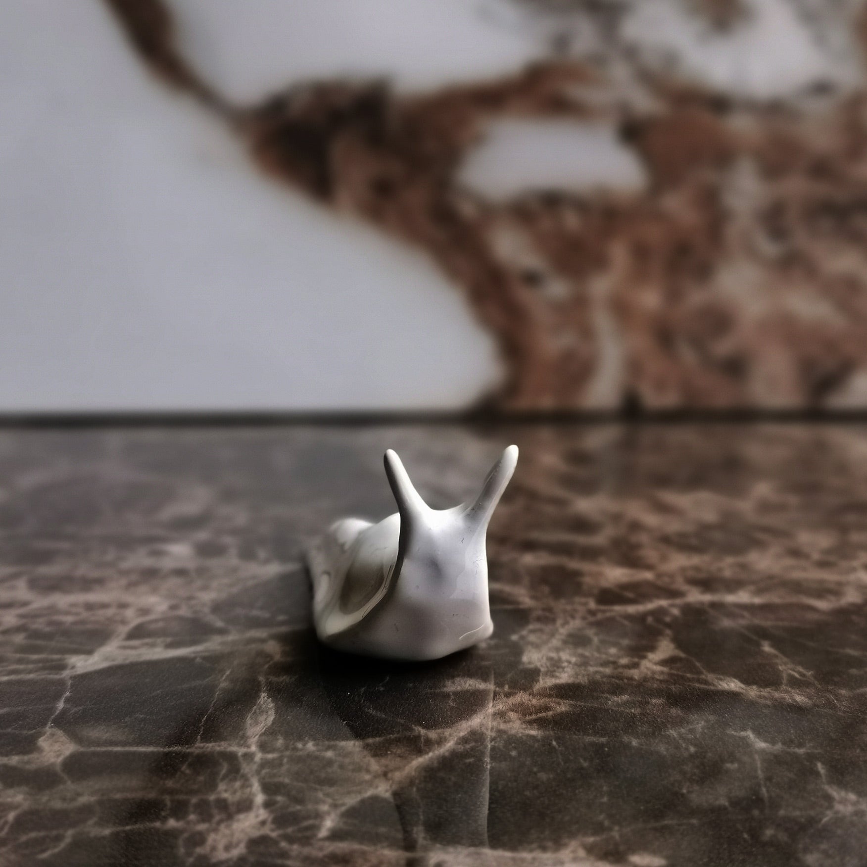 Lumaca in ceramica bianca su sfondo neutro frontale— Wasetti